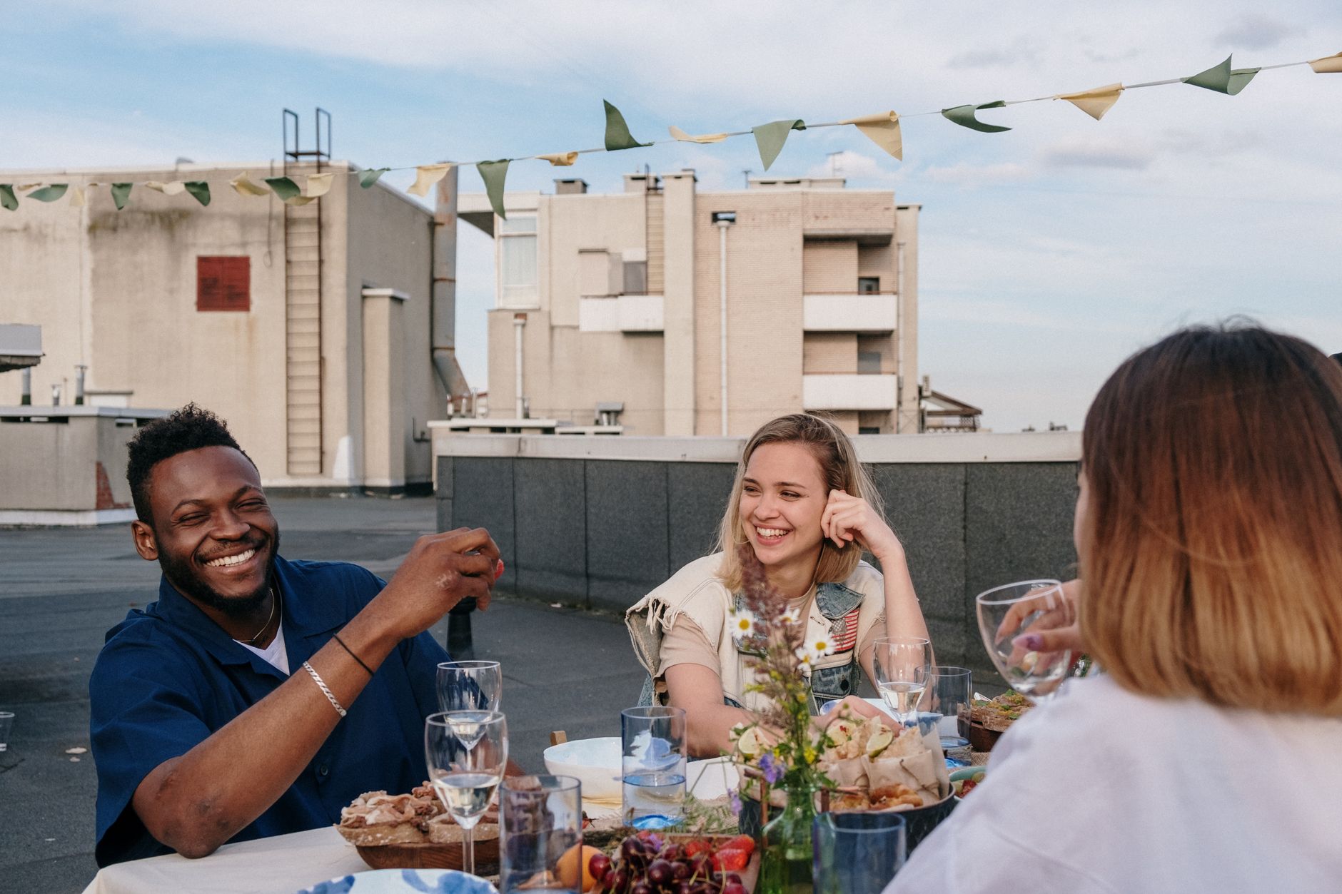 Friends sharing dinner at a long outdoor table