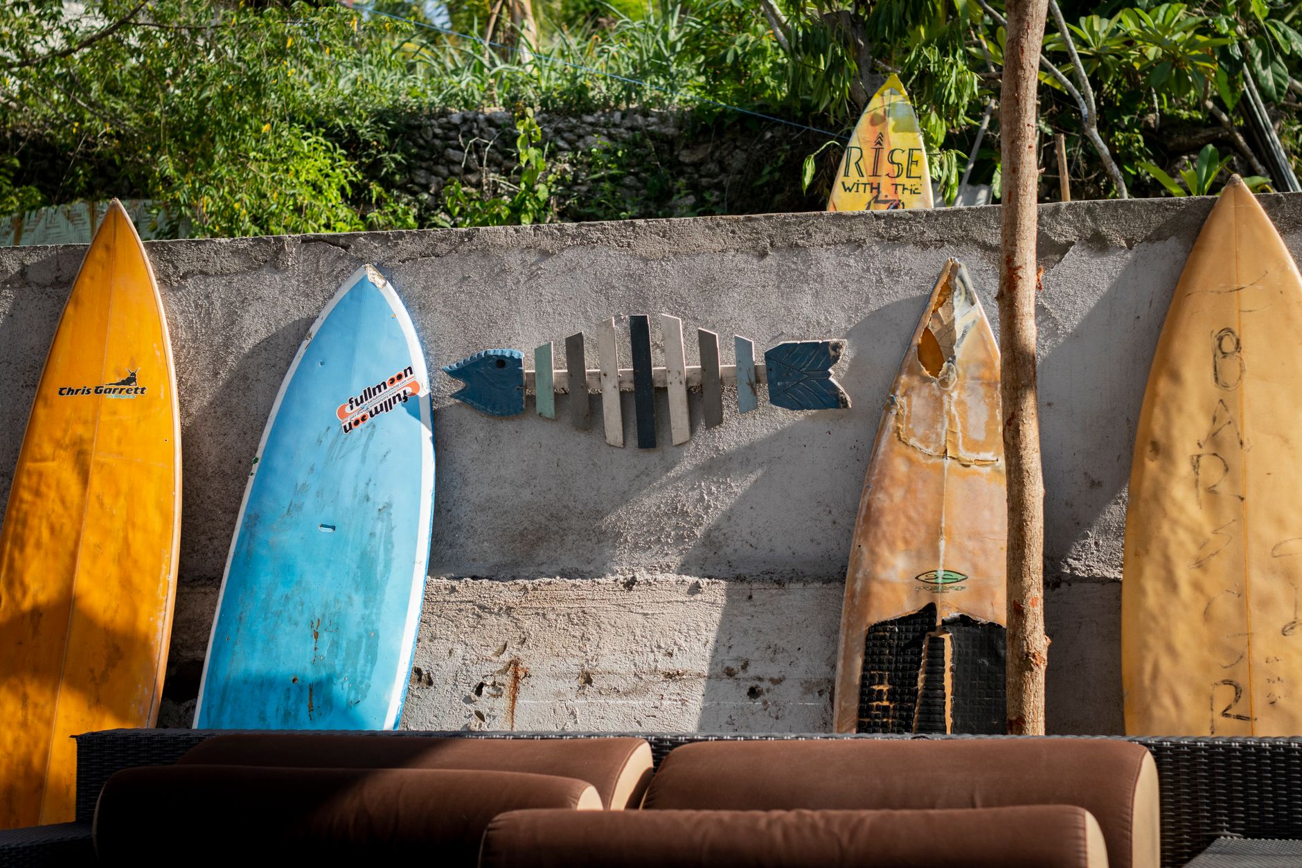 Row of colourful surfboards leaning against a wall