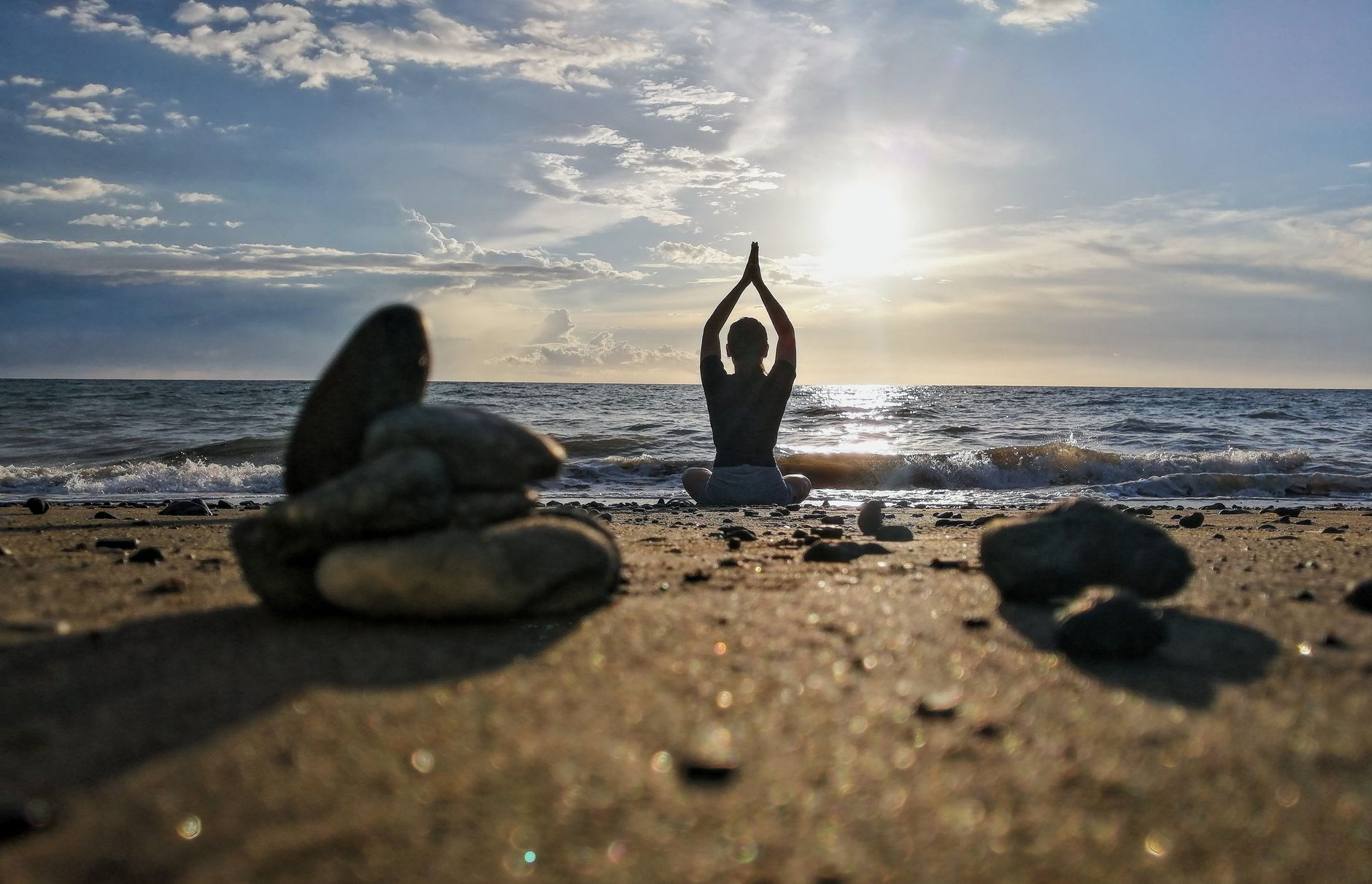 Maya Lindqvist, yoga teacher, in a yoga pose on the sand at golden hour
